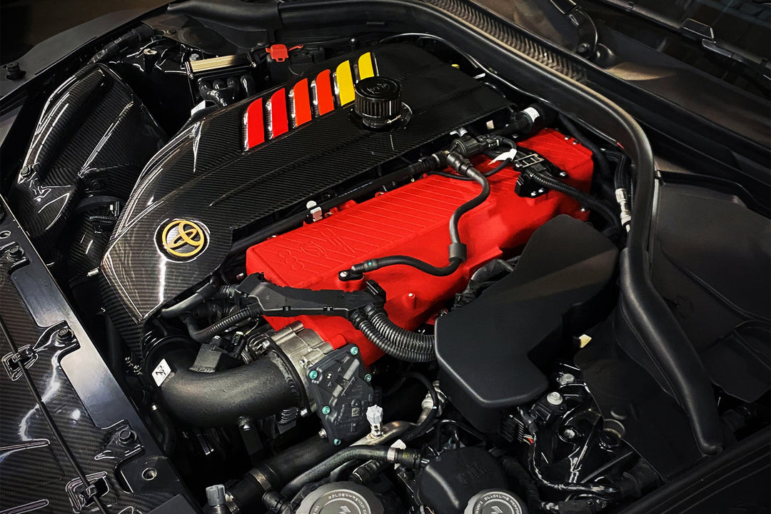 CSF B58 charge air cooler manifold in red installed in a Toyota GR Supra engine bay